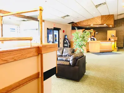 a waiting area with a leather chair in a waiting room at Northern Star Hotel & Convention Center in Slave Lake