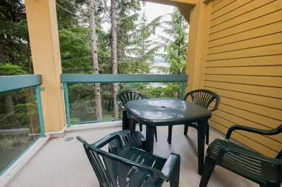 a porch with a table and chairs and a window at Snowbird by Bill in Whistler