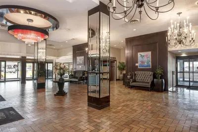 a lobby with a chandelier and a large lobby with a lobby at Coast Prince George Hotel by APA in Prince George