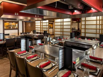 a dining room with tables and chairs and a restaurant at Coast Prince George Hotel by APA in Prince George