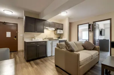 a living room with a couch and a kitchen at Best Western Premier Aberdeen Kamloops in Kamloops