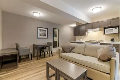 a living room with a couch and a kitchen at Best Western Premier Aberdeen Kamloops in Kamloops