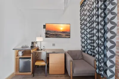 a living room with a desk and a chair at Savoy Hotel in Nelson