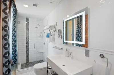 a white bathroom with a sink and a toilet at Savoy Hotel in Nelson