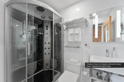 a bathroom with a shower and a toilet and a sink at Savoy Hotel in Nelson