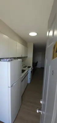 a kitchen with white appliances and a white refrigerator at Riverside Motel in Penticton