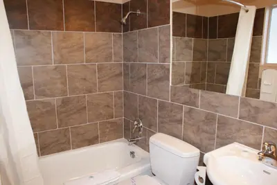 a bathroom with a tub and a toilet and a sink at Riverside Motel in Penticton