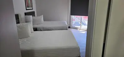two beds in a hotel room with a window at Riverside Motel in Penticton