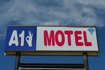 a billboard sign for a motel with a sign for a mcdavid at A1 Motel And Campground in Bassano