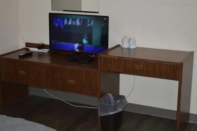 a tv sitting on a wooden desk with a television on it at A1 Motel And Campground in Bassano