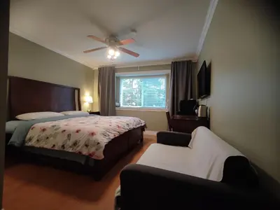a bedroom with a bed and a ceiling fan at Three Kittens Guesthouse in Burnaby