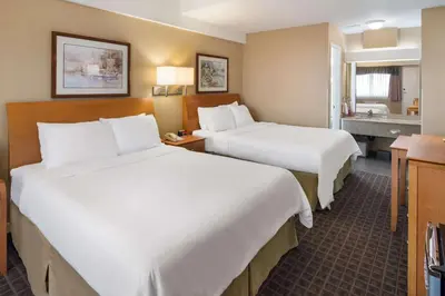 a hotel room with two beds and a bathroom at SureStay by Best Western North Vancouver Capilano in North Vancouver