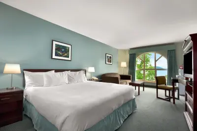 a hotel room with a large bed and a window at Harrison Lake Hotel in Harrison Hot Springs
