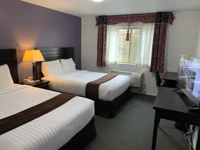 a hotel room with two beds and a desk at Lake Country Inn in Winfield