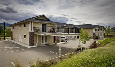 a building with a balcony and a parking lot at Lake Country Inn in Winfield