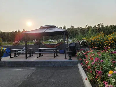 a gazebo with a hammock and benches and flowers at Lake Country Inn in Winfield
