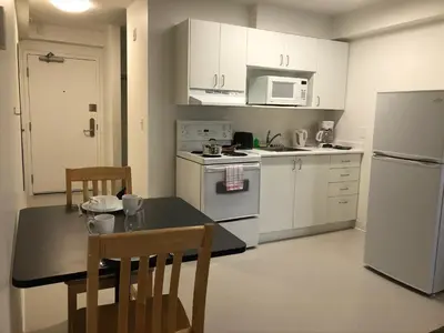 a kitchen with white appliances and a table and chairs at UBC Okanagan Campus in Kelowna