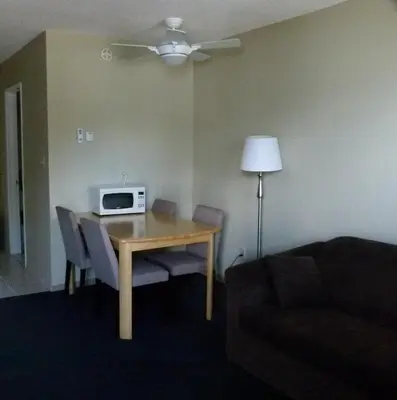 a living room with a table with a microwave on it at Schell Motel in Vernon