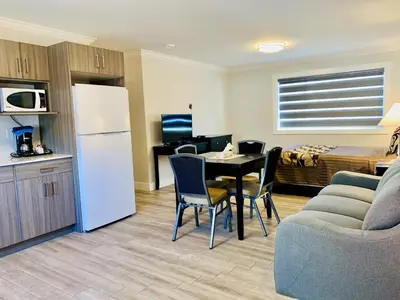 a room with a kitchen and a table and a bed at Traveler's Motel Penticton in Penticton