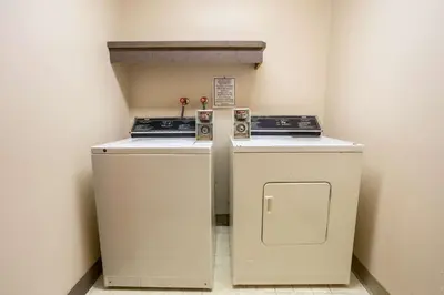 two washing machines in a corner of a room at Ramada by Wyndham Cranbrook in Cranbrook