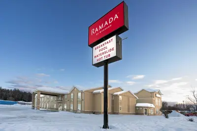 a sign in the snow in front of a building at Ramada by Wyndham Cranbrook in Cranbrook