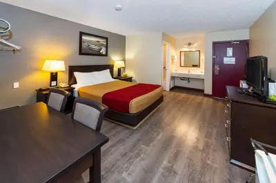 a hotel room with a bed and a desk at Econo Lodge in Edson