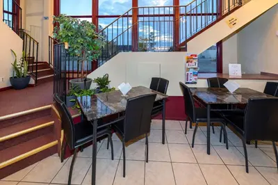 a dining room with two tables and chairs and stairs at Econo Lodge in Edson