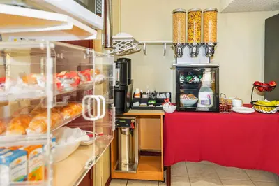 a kitchen with a counter with a red table at Econo Lodge in Edson