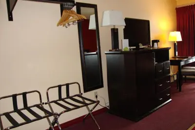 a room with a mirror and a chair and a dresser at Econo Lodge in Edson
