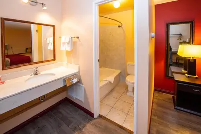 a bathroom with a sink and a tub and a toilet at Econo Lodge in Edson