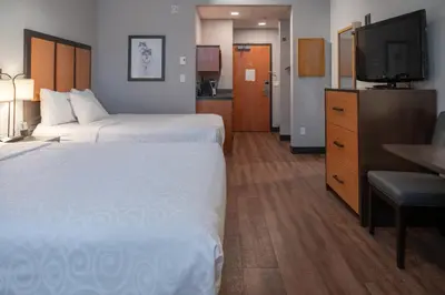 a hotel room with two beds and a flat screen tv at Pocaterra Inn & Waterslide in Canmore