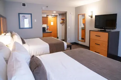 a hotel room with two beds and a flat screen tv at Pocaterra Inn & Waterslide in Canmore