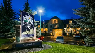 a sign in front of a house at night at Pocaterra Inn & Waterslide in Canmore