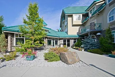 a house with a garden in front of it at Pocaterra Inn & Waterslide in Canmore