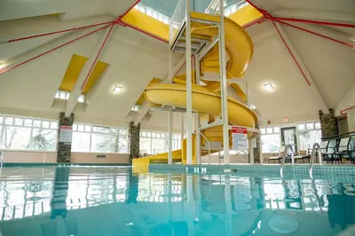 a swimming pool with a slide in a building at Pocaterra Inn & Waterslide in Canmore