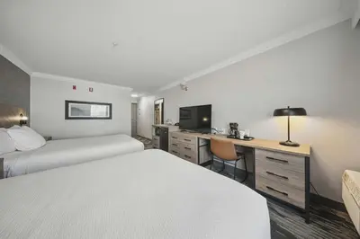 a hotel room with two beds and a desk at Sandman Hotel Red Deer in Red Deer