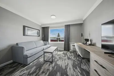 a living room with a couch and a television at Sandman Hotel Red Deer in Red Deer