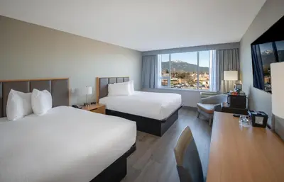 a hotel room with two beds and a desk at Coast Chilliwack Hotel by APA in Chilliwack