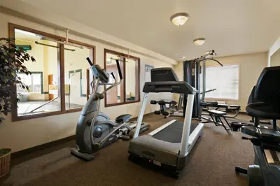 a fitness room with a treadmill and exercise bikes at Super 8 by Wyndham Fort Nelson BC in Fort Nelson