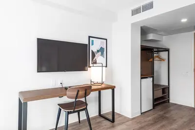a home office with a desk and a tv on a wall at Hotel Willo - previously known YWCA Hotel in Vancouver