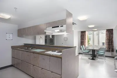 a kitchen with a counter and a table and chairs at Hotel Willo - previously known YWCA Hotel in Vancouver