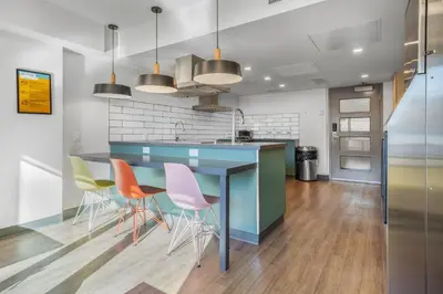 a kitchen with a blue counter and chairs at Hotel Willo - previously known YWCA Hotel in Vancouver