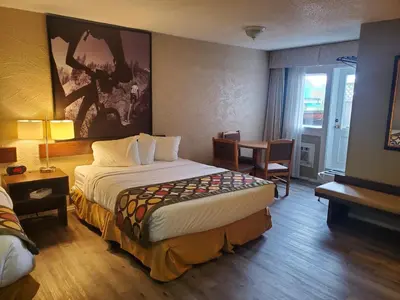 a hotel room with a large bed and a table at Super 8 by Wyndham Duncan in Duncan