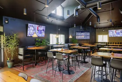 a restaurant with tables and chairs in a room at Balcomo, a Ramada by Wyndham in Penticton