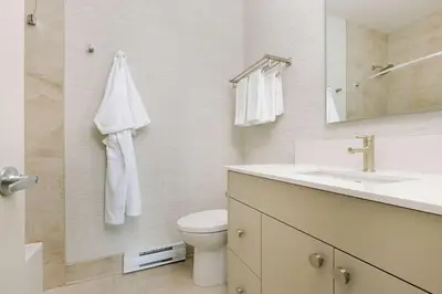 a bathroom with a sink and a toilet and a mirror at Balcomo, a Ramada by Wyndham in Penticton