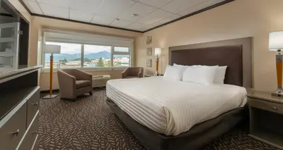 a hotel room with a bed and a large window at Prestige Oceanview Hotel Prince Rupert in Prince Rupert
