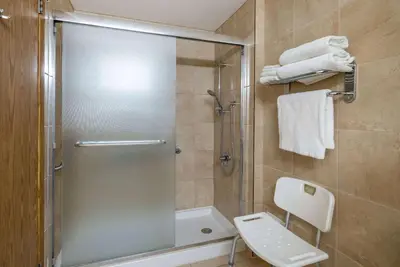 a bathroom with a shower with a toilet and a sink at Super 8 by Wyndham Edmonton International Airport in Leduc
