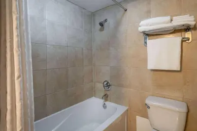 a bathroom with a white tub and a toilet at Super 8 by Wyndham Edmonton International Airport in Leduc