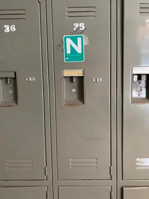 a row of metal lockers with a sign on them at Vancouver Backpacker House - 10 min walk to Metrotown skytrain station in Burnaby