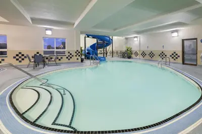a swimming pool with a slide in a hotel room at Best Western Premier Freeport Inn Calgary Airport in Calgary